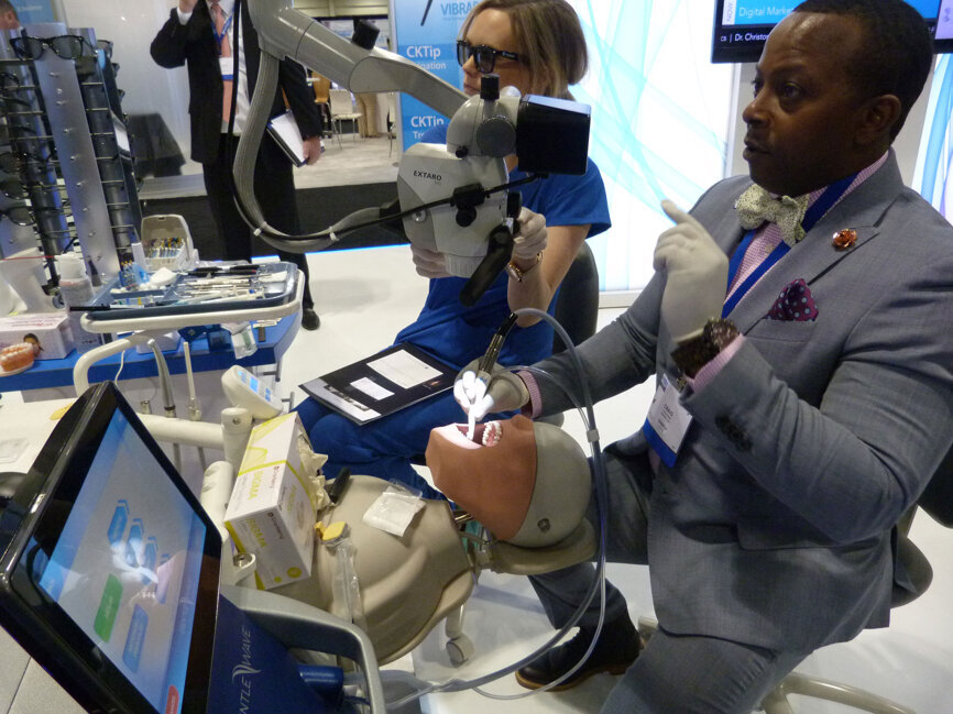 Craig O’Neal prepares a GentleWave demonstration unit with assistance from dental assistant Chelsi Thomas in the Sonendo booth.