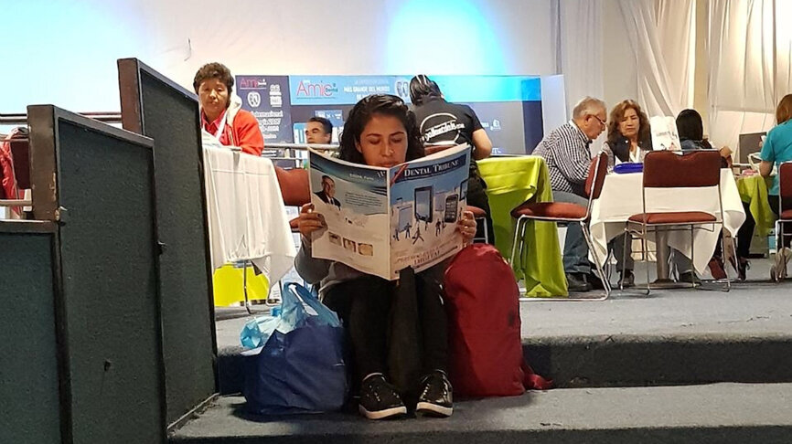 Una odontóloga se toma un descanso para leer Dental Tribune.