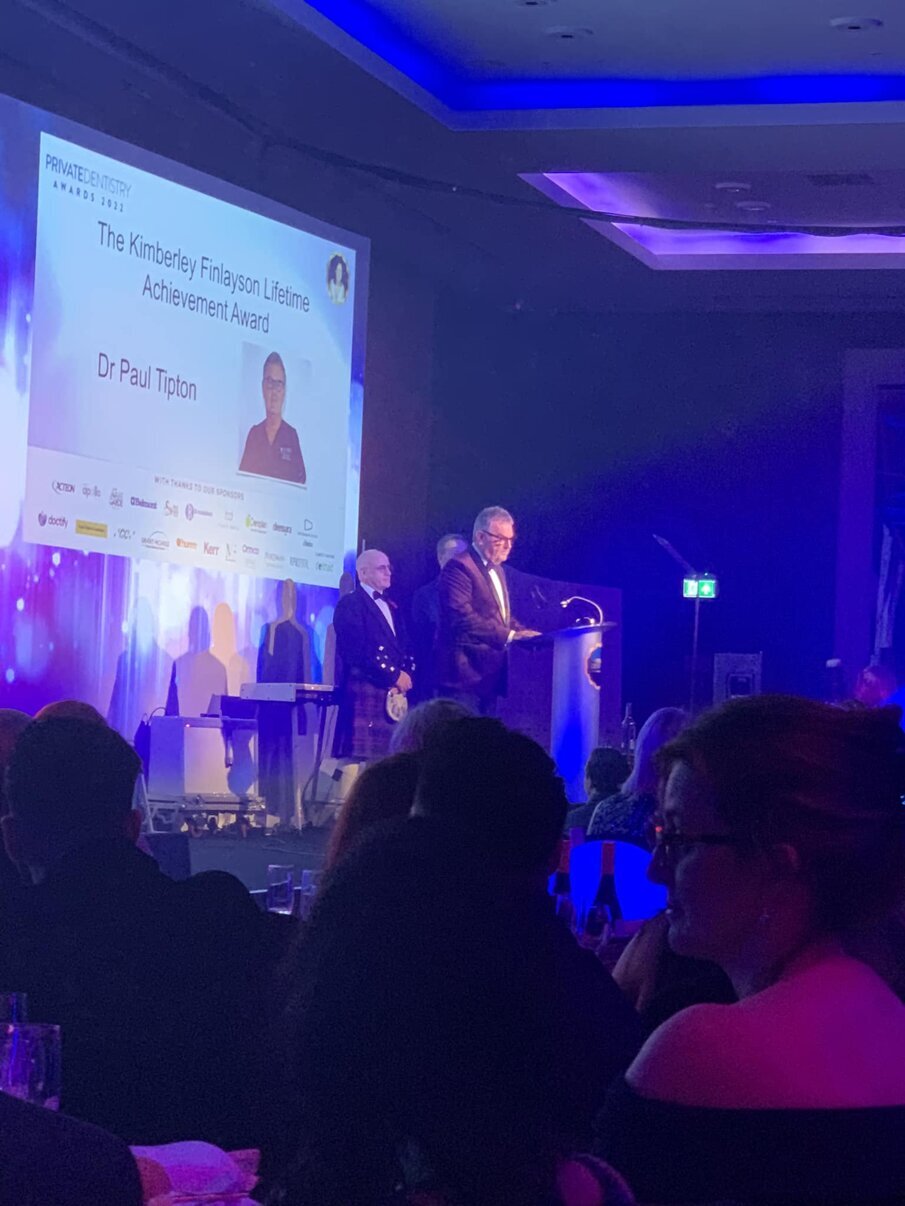 Prof Tipton giving speach on the stage of the Awards