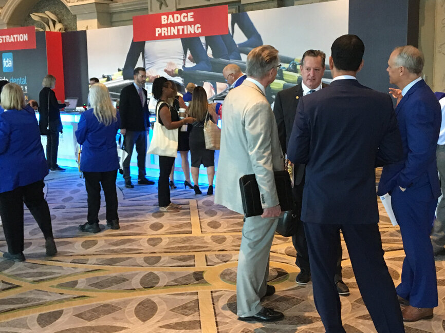 Attendees mill around the registration area Thursday morning during the FDC.