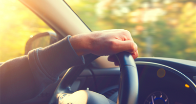 Mann putzt sich Zähne hinterm Steuer