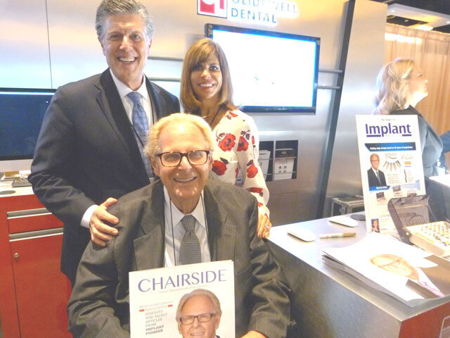 In the Glidewell Dental booth, Dr. Jack Hahn, seated, with Dr. Neil Park and Jennifer Archer.