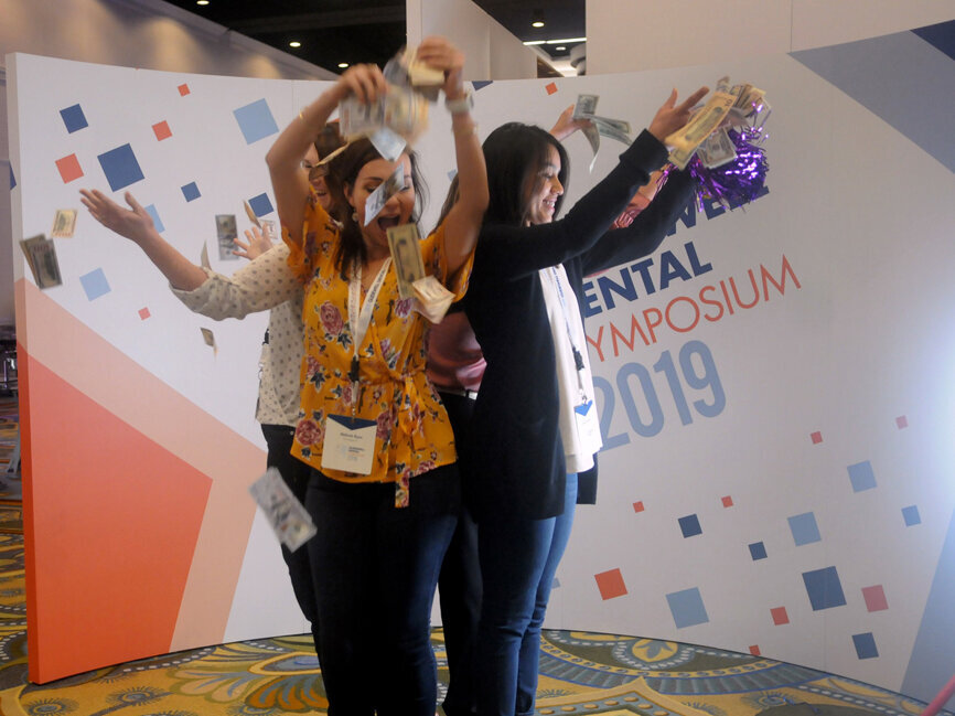 A slow motion photo booth were fake money was thrown away as a way to simbolize savings from using Glidewell products. (Photo: José Antonio Rosario for Dental Tribune)