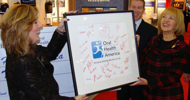 Henry Schein presents check and new logo design to OHA