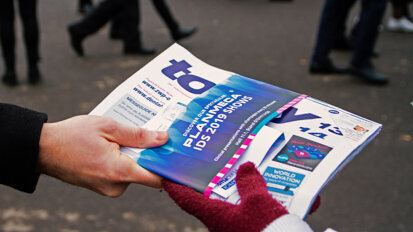 Dental professionals receiving the today at IDS newspaper from Wednesday. (Photograph: Luke Gribble, DTI)