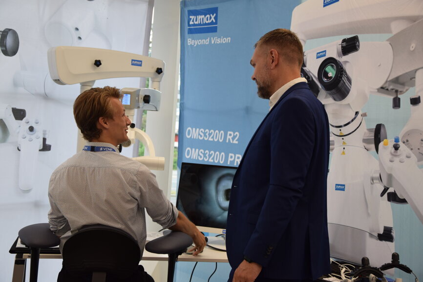 Demonstration of the OMS 3200 dental microscope at the Zumax booth.