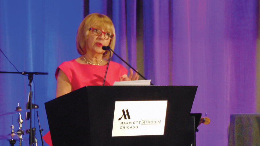 Beth Truett, president and CEO of Oral Health America, offers recognition to some of the OHA’s biggest contributors. (Photo: Fred Michmershuizen, DTA)