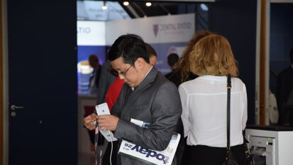 A congress attendee with his copy of the today newspaper. (Photograph: DTI)