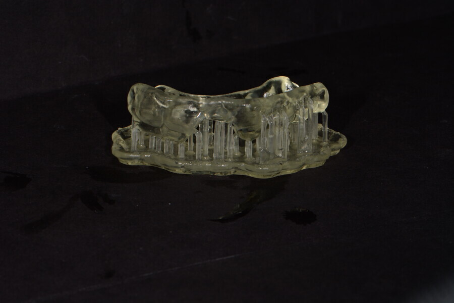 Fig. 9: Surgical guide made from V-Print SG (VOCO) still on supports from the printer.