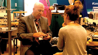 Marty O’Rourke of Designs for Vision helps a clinician pick out loupes. (Photo: Leerol Colquhoun/DTA)
