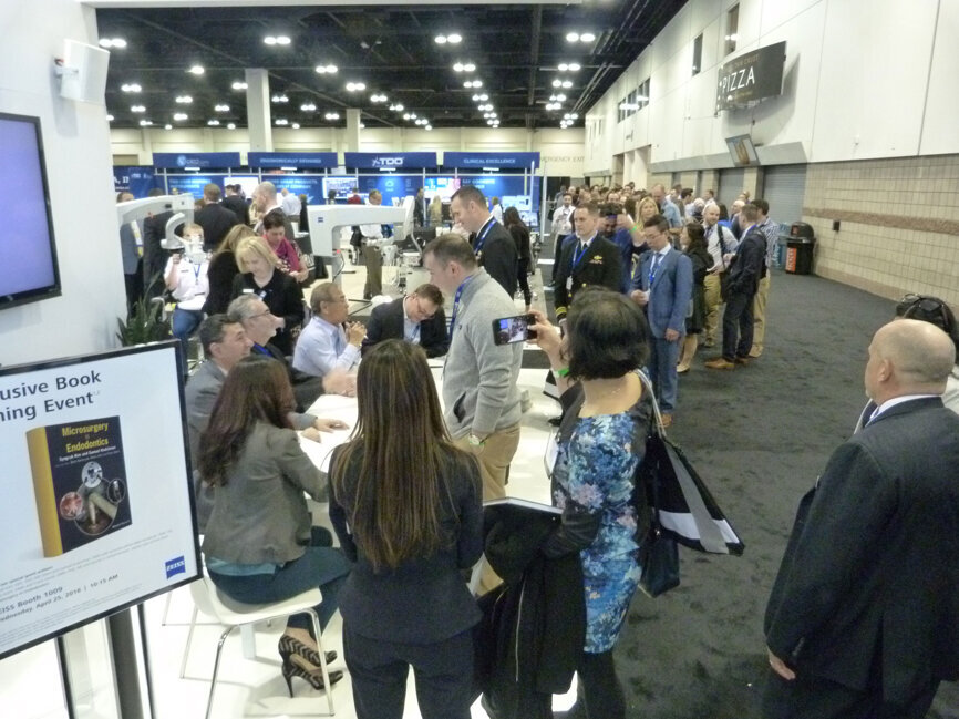 The line stretches more than 100-people deep in the Zeiss booth for a book signing event with authors Syngcuk Kim, DDS, PhD, MD (Hon), and Samuel Kratchman, DMD, and associate editors Bekir Karabucak, DMD, Meets Kohl, DMD and Frank Setzer, DMD, PHD. The book is ‘Microsurgery in Endodontics.’