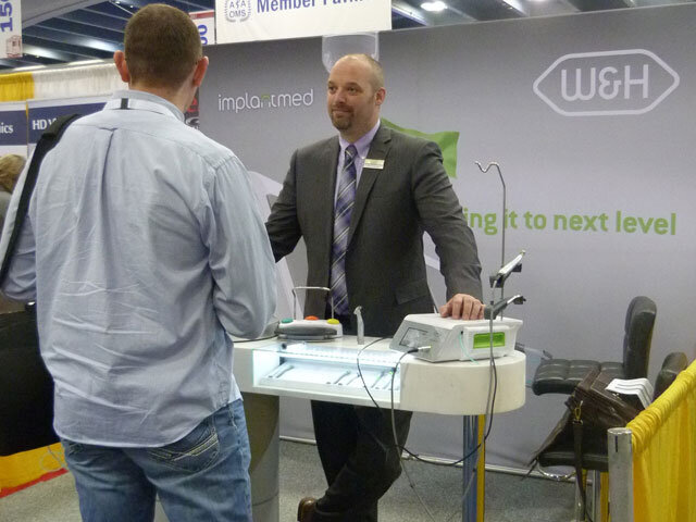 Brian Schiefer helps an AAOMS attendee discover the latest in W&H surgical products.