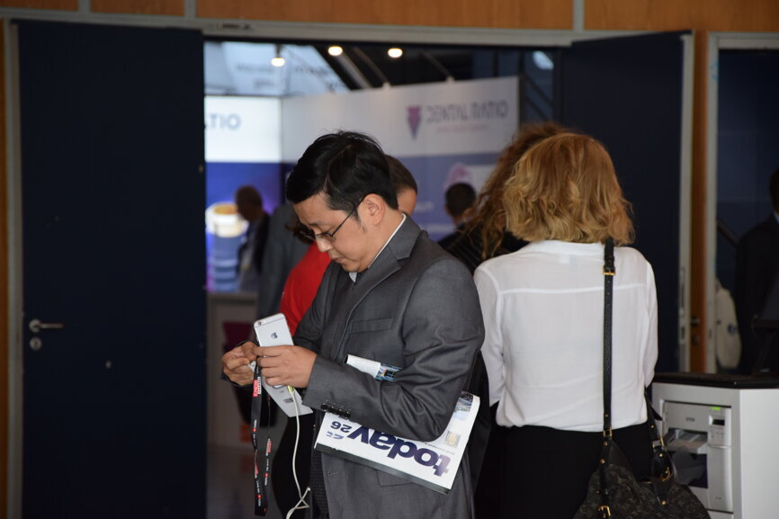 A congress attendee with his copy of the today newspaper. (Photograph: DTI)