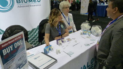 In the Avalon Biomed booth, Hugo Munoz, DDS, of Guatemala City, Guatemala, learns more about NeoMTA Plus after having worked with a sample. Helping him, from left, is Nikki Ruck and Carolyn Primus, PhD.