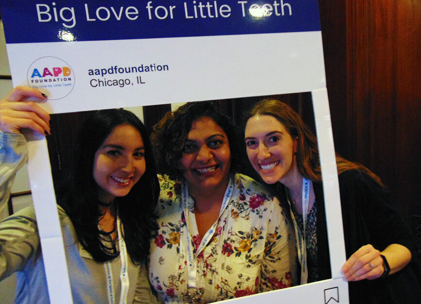 From left: Michelle Hidalgo, Dr. Reem Hemantharaju and Dr. Hillary Khodari pose for a fun picture to help promote the AAPD Foundation, where to motto is ‘big love for little teeth.’ (Photo by Fred Michmershuizen/Dental Tribune America) 