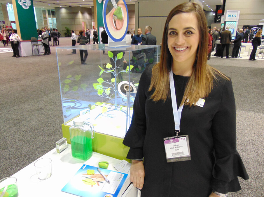 Shelby McCollister of Kulzer offers demonstrations of the new Ivory ReLeaf HVE suction device. (Photo: Fred Michmershuizen/Dental Tribune America)