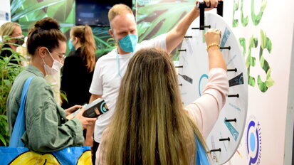 IDS visitors are spinning the wheel of fortune to win oral hygiene products at the happy brush stand. (Image: Dental Tribune International)