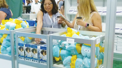 Attendees check out the items on sale at the AAPD Store booth, like the tooth toys and the T-shirts.