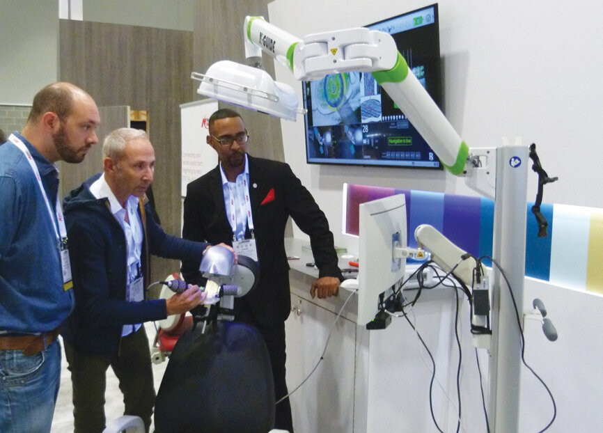 Jamar Matthews offers Dr. Jerome Liberman an opportunity to test out X-Guide at the Nobel Biocare booth. (Photo: Sierra Rendon/DTA)