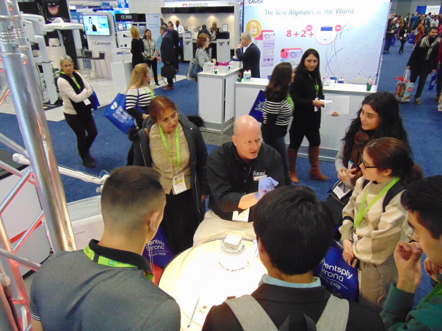 Adam Kroos of Fotona offers an in-booth educational presentation about lasers to meeting attendees. (Photo: Fred Michmershuizen/DTA)