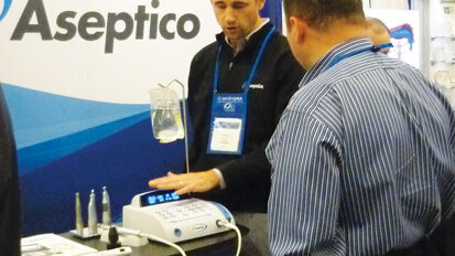 Chris Berry shows an attendee the benefits of the Aseptico implant motor. Photo by Sierra Rendon/DTA
