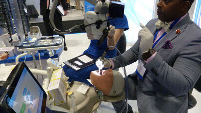 Craig O’Neal prepares a GentleWave demonstration unit with assistance from dental assistant Chelsi Thomas in the Sonendo booth.