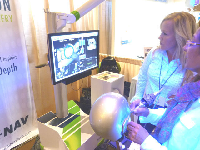 Brandi Ratliff of X-Nav Technologies guides AAID Associate Fellow Dr. Ninette Branday of the United Arab Emirates in the use of the X-Guide by X-Nav Technologies.