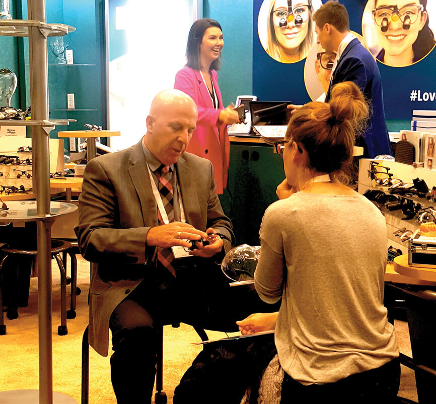 Marty O’Rourke of Designs for Vision helps a clinician pick out loupes. (Photo: Leerol Colquhoun/DTA) 