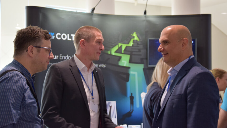 Attendees in conversation at the COLTENE booth. 