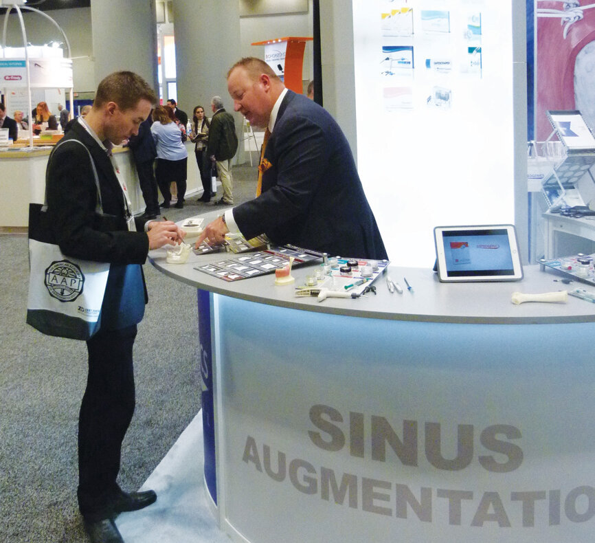 Russ Rowan of Osteogenics Biomedical shows an attendee the latest in sinus augmentation. (Photo: Sierra Rendon/DTA)