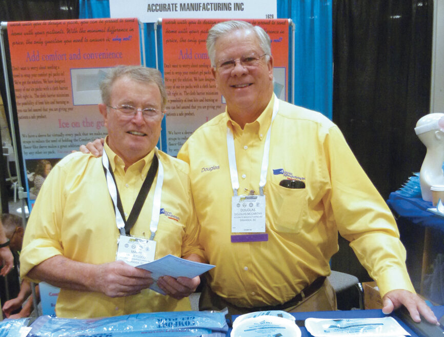 At the Accurate Manufacturing booth, Douglas McArthur and Mauri Flood offer samples of the company’s gel packs, which can be used either hot or cold for pain relief. (Photo: Sierra Rendon/DTA)