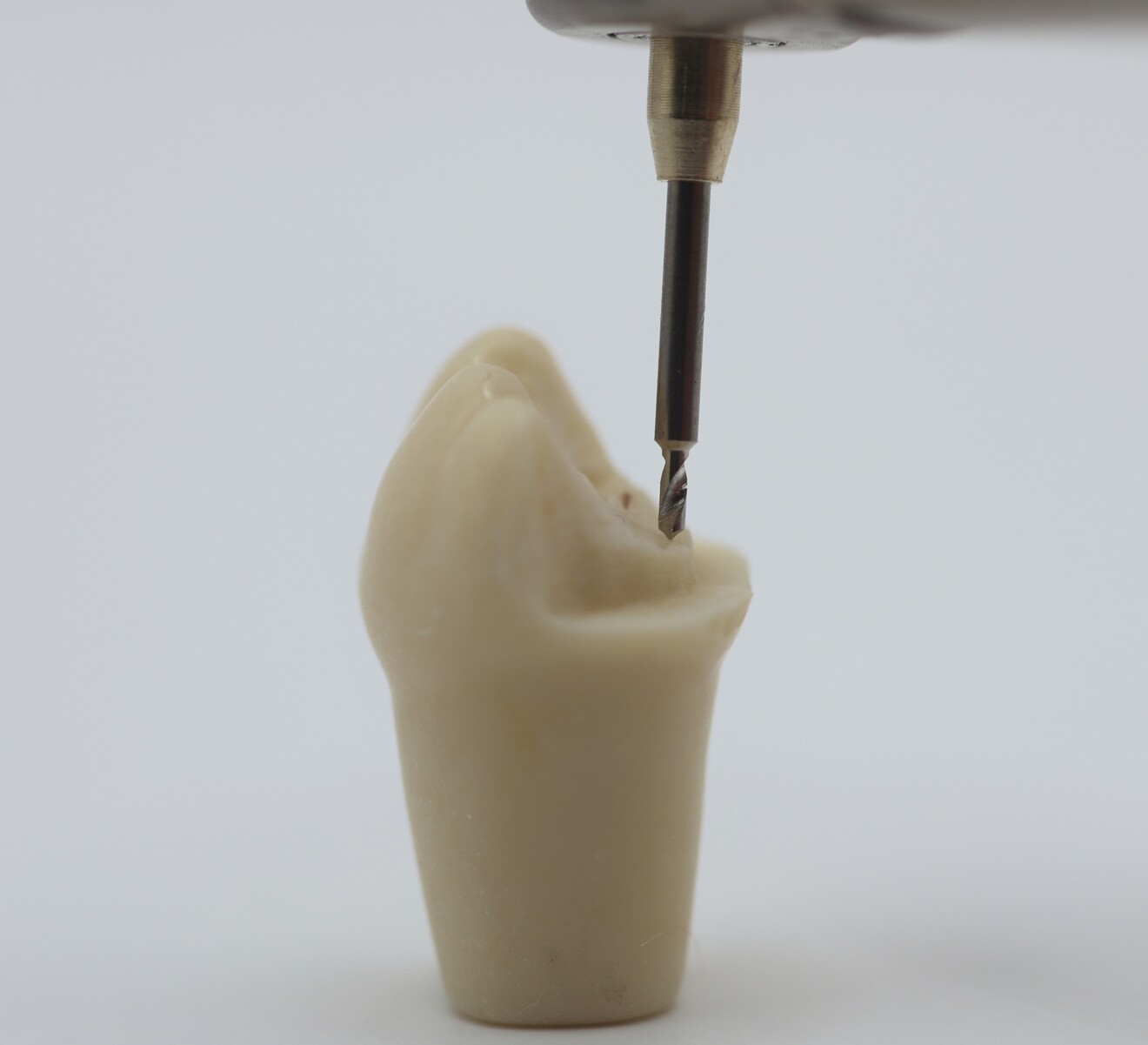 Fig. 3b:  Alignment of the drill with the prepared dentoform tooth before pinhole preparation.