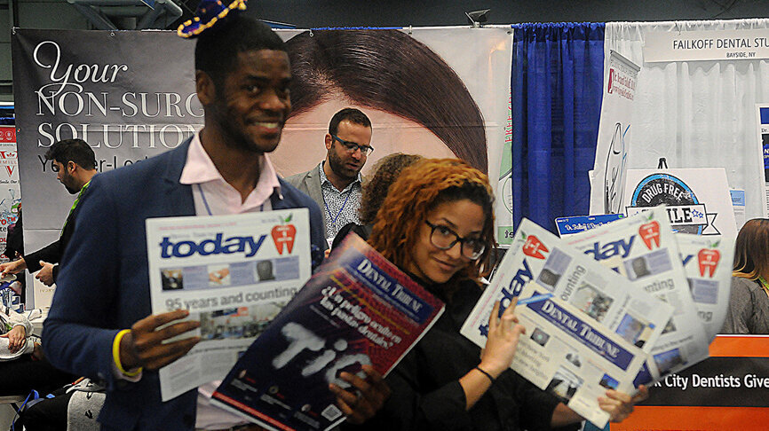 Lee Colquhoun y Katherine Pagano con ejemplares de “GNYDM Today”, la publicación de ferias de Dental Tribune, de la cual se distribuyen cuatro ediciones diferentes en la expo de Nueva York. (Foto: José Antonio Rosario para Dental Tribune)