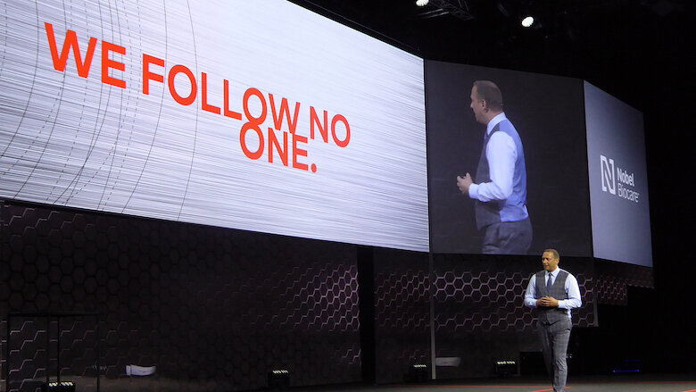 El presidente de Nobel Biocare, Hans Geiselhöringer, durante la presentación en Madrid del nuevo sistema de implantes N1. La frase en la pantalla alude a que se trata de una compañía líder que no sigue a nadie sino que presenta productos innovadores. (Fotos: Javier de Pisón)