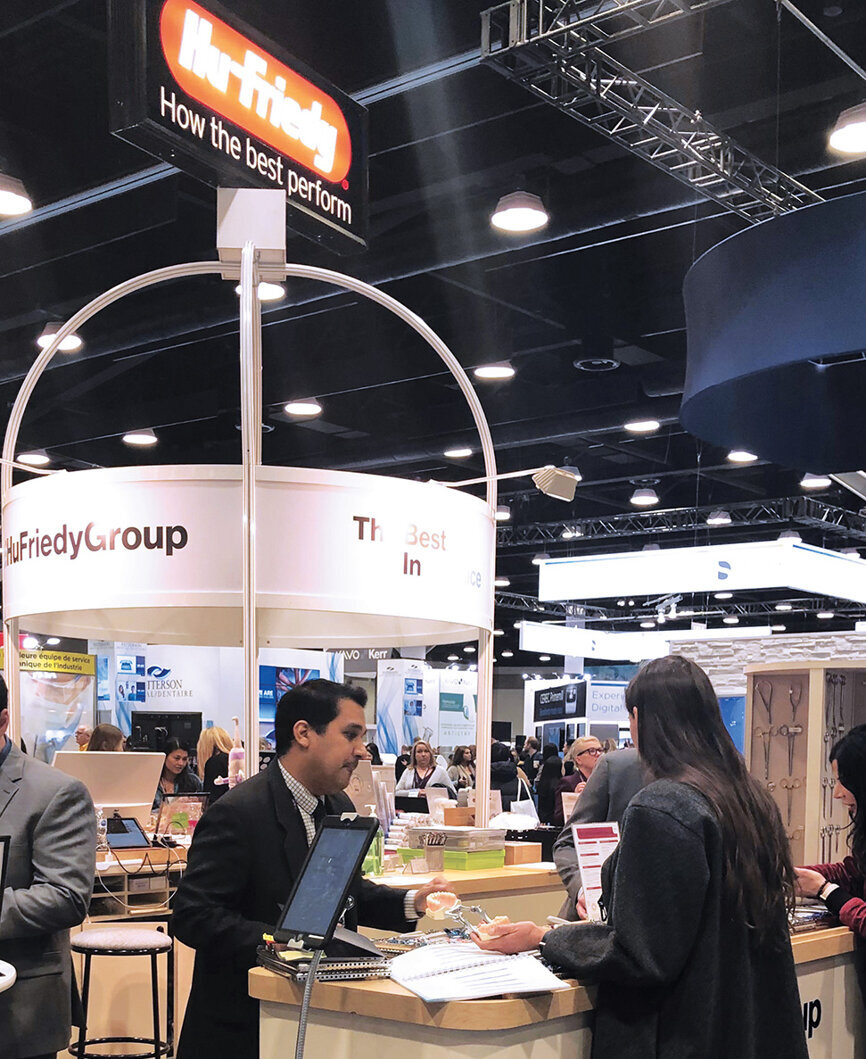 Romeo Fermin of Hu-Friedy helps Dr. Oxana Korj pick out equipment at the towering Hu-Friedy booth.