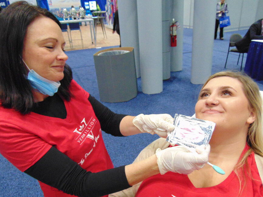 Becky Adres, RDH, left, and Lauren Giordano of Vermillion Cosmetics demonstrate the application of the company’s LiPro rejuvenation treatment for lips. (Photo: Fred Michmershuizen/DTA)
