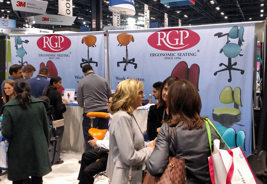 Dental professionals visit the RGP booth for ergonomic seating. (Photo: Humberto Estrada, Dental Tribune America)