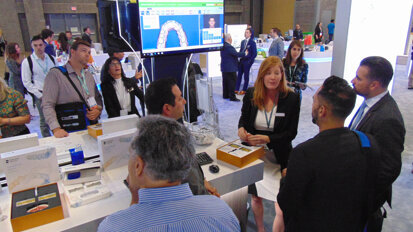 Meeting attendees get more information about the SureSmile aligner system at the Dentsply Sirona Orthodontics booth.