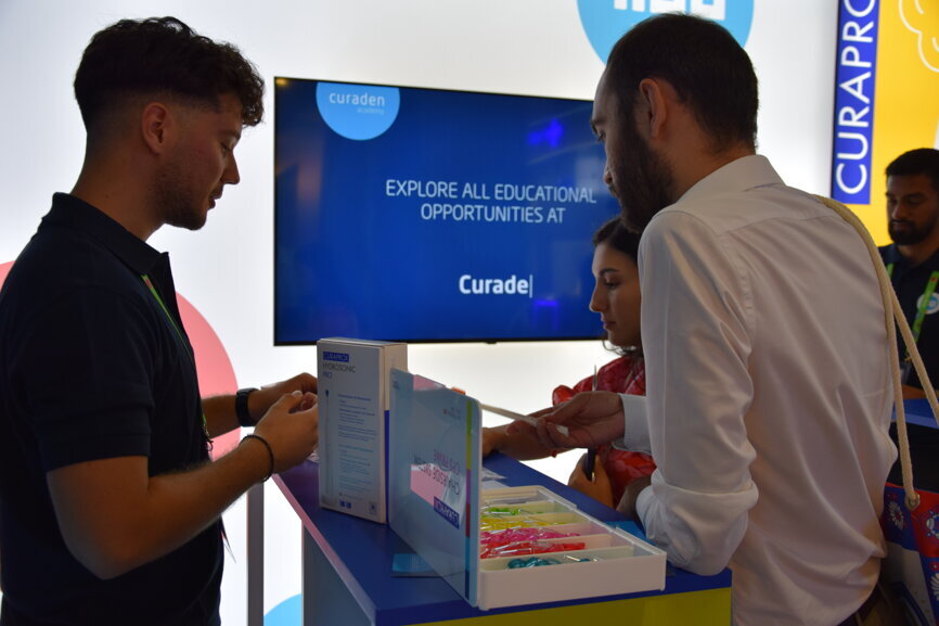 A participant dives deeper into the prevention and the preservation of oral health at the Curaden booth.