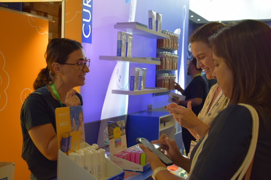 A participant explores the latest in preventive oral care at the Curaden booth.