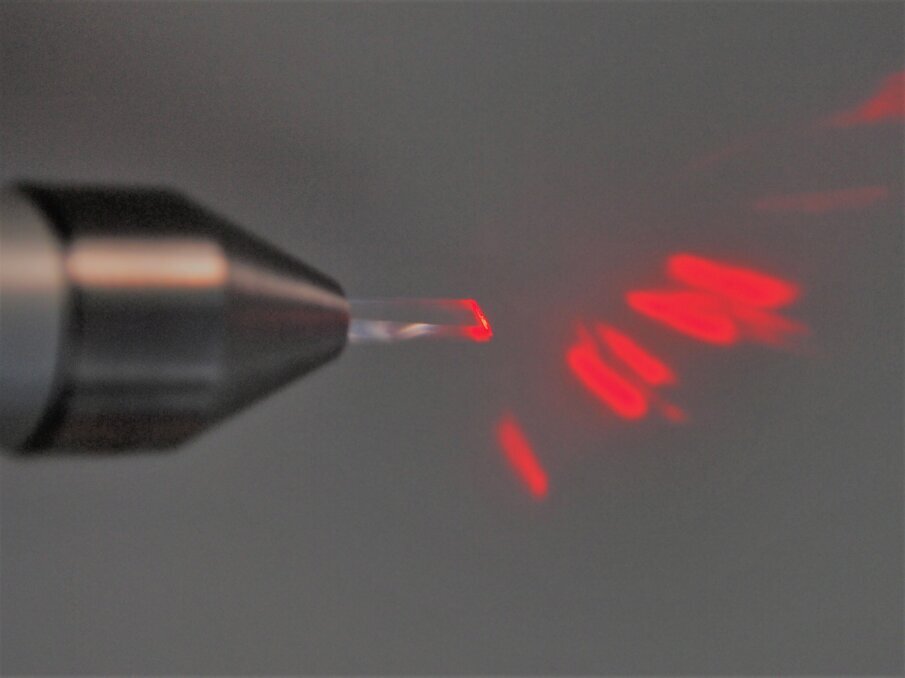 Fig. 1 - Inserto intercambiabile in zaffiro montato su specifico manipolo. In modalità non attivata è possibile osservare la proiezione del fascio guida attraverso il prisma in zaffiro.