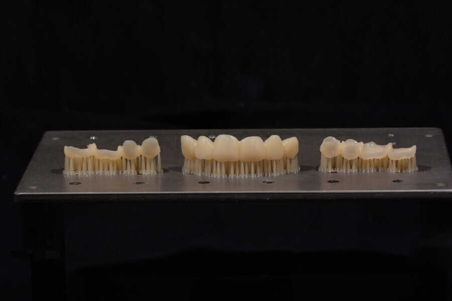 Fig. 9: 3D-printed provisional restorations on the build platform and evident supporting structures.
