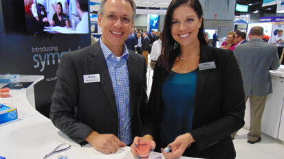 Brett Kowald, left, and Suzanne Wilson of Ormco demonstrate the company’s new Symetri Clear brackets.