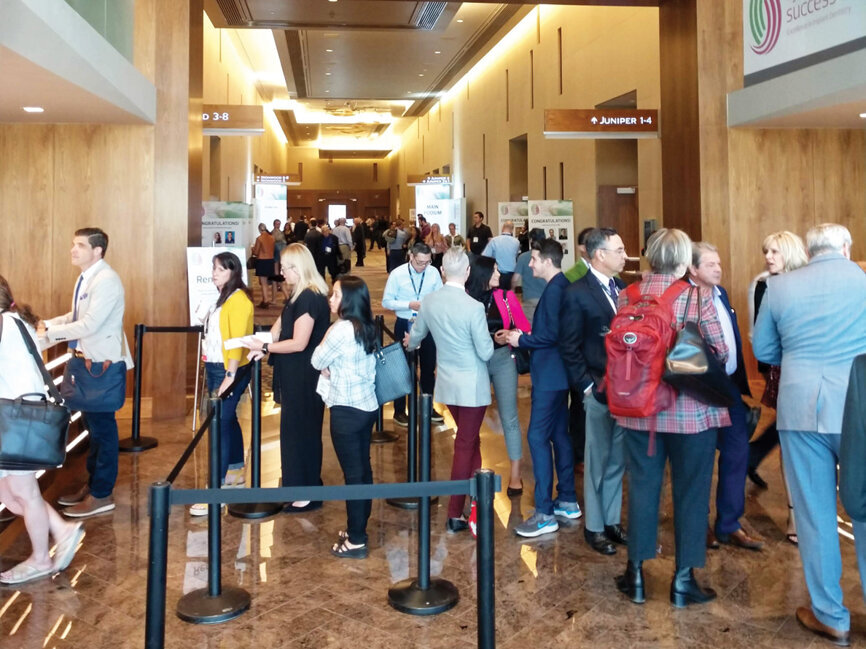AAID attendees eagerly line up at the registration booth Thursday morning.