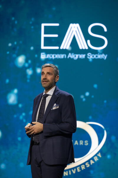 Dr Vincenzo D'Antò presenting his clinical insights on stage.