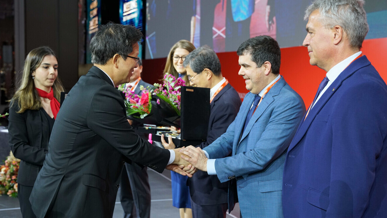 Dr Kyoo-Ok Choi shaking hands with Dr Marco Tallarico, who presented at the event. 