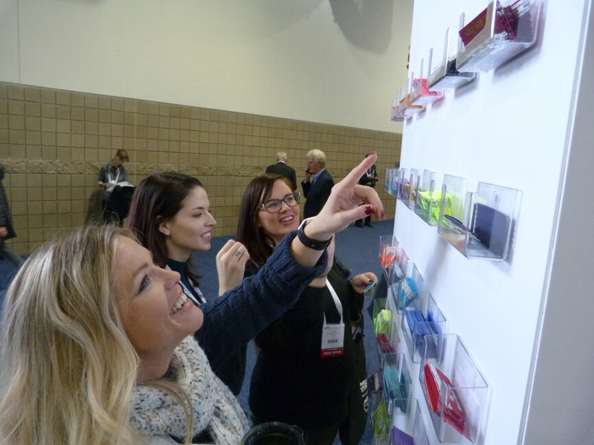 From left, Stacey Yocubets, chairside assistant; Kayla Benson, front office personnel; and Keri Tatum, front office personnel, all with the Just for Grins dental practice in Falcon, Colo., pick out some ‘Flair For Your Badge’ upon entering the exhibit hall at the 2019 Rocky Mountain Dental Convention. Their respective choices: ‘Tradeshow Diva,’ ‘Body by Bacon’ and ‘Somebody.’ (Photo: Robert Selleck/Dental Tribune America)