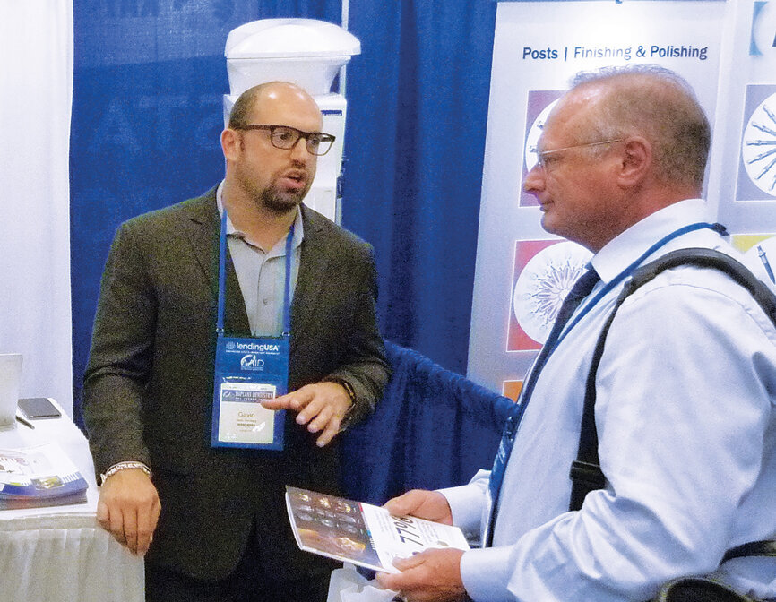 Gavin Sternberg answers question for an attendee at the Planmeca booth. Photo by Sierra Rendon/DTA