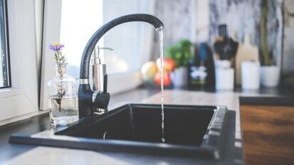 Zwarte aanslag door kraanwater met hoog ijzergehalte