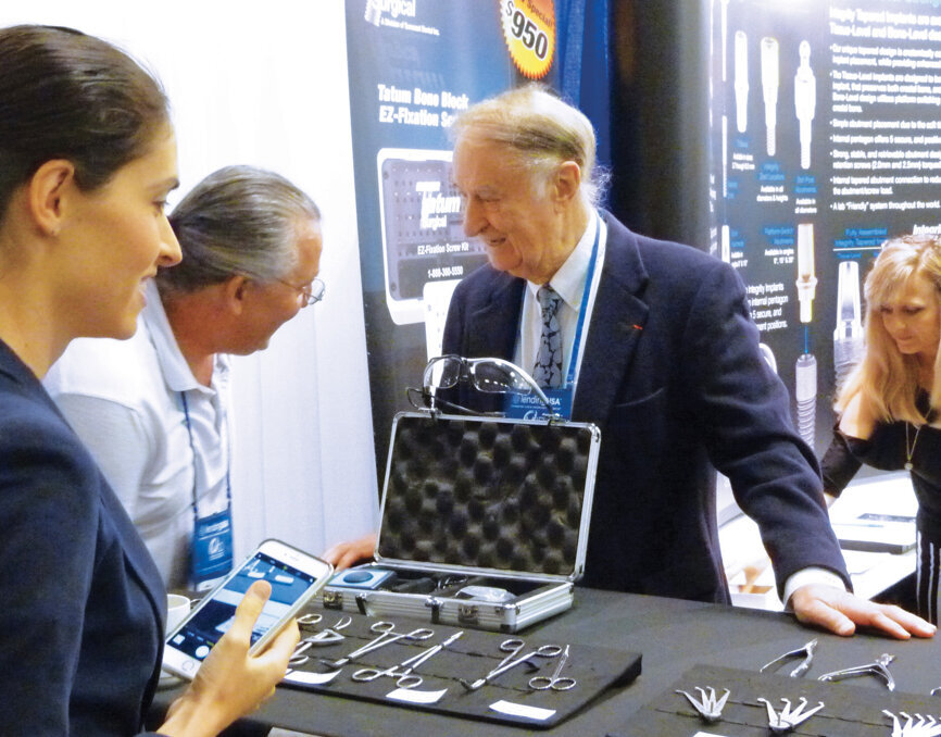 Dr. Hilt Tatum Jr., widely regarded as a true pioneer in the field of implant dentistry, visits with colleagues at the Tatum Surgical booth. Photo by Sierra Rendon/DTA
